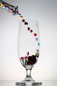 Close-up of wine glass on table against white background