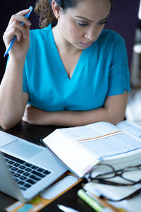 Midsection of woman using mobile phone while sitting on table
