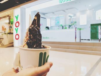 Midsection of person holding ice cream at home