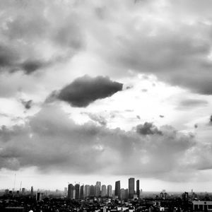 Aerial view of buildings in city against sky