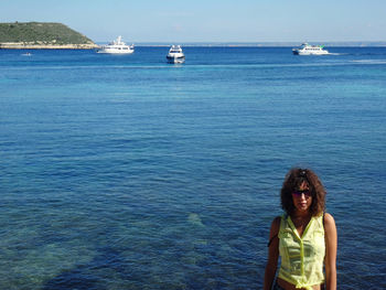 Portrait of young woman in mediterranean sea against sky