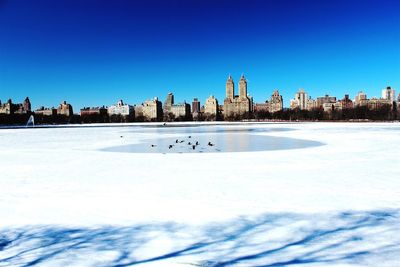 View of cityscape against clear blue sky
