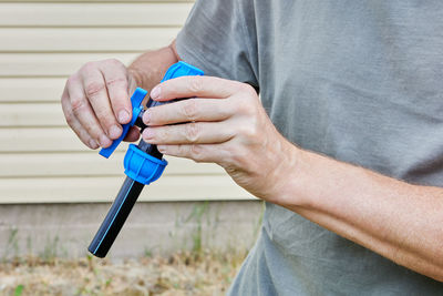 Midsection of man holding thermometer