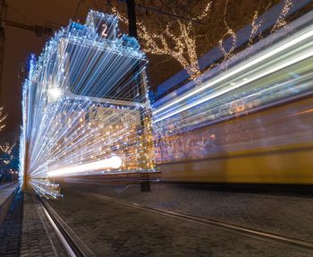 Blurred motion of cable cars on street in city at night