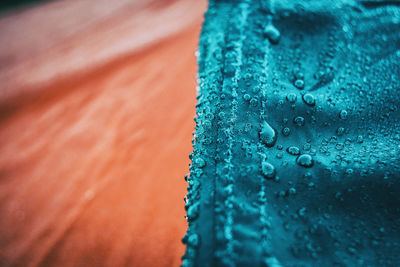 Full frame shot of raindrops on blue glass