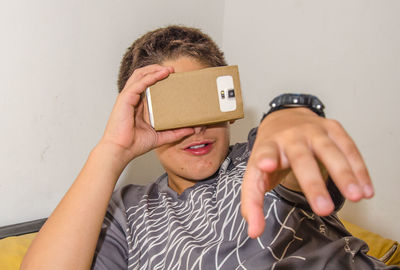 Close-up of boy watching in smart phone through cardboard virtual reality simulator