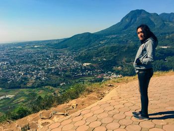 Full length of woman standing on mountain against sky