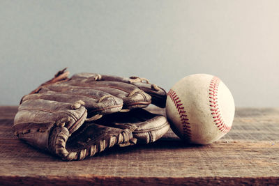 Close-up of baseball glove and ball on table