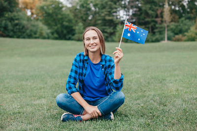 Young woman sitting on grassy field