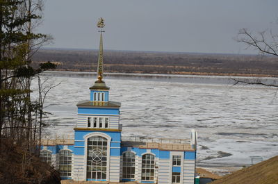 Building by sea against sky