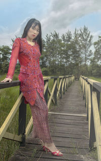 Woman on railing against trees