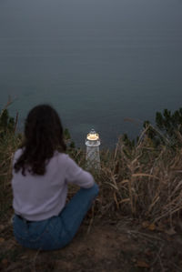 Rear view of woman looking at lake shore