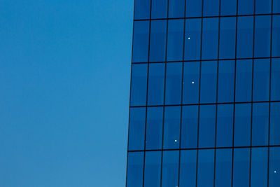 Low angle view of modern building against blue sky