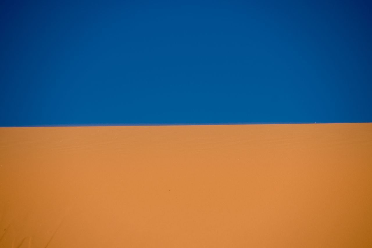 SCENIC VIEW OF SAND DUNES AGAINST CLEAR SKY