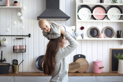 Portrait of young woman standing in kitchen