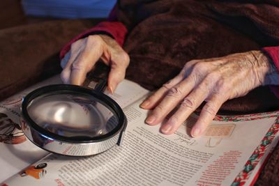 Midsection of woman reading book on table