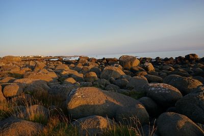 Rocks in sea against clear sky