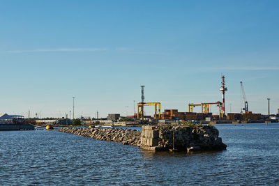 Harbor by sea against clear blue sky