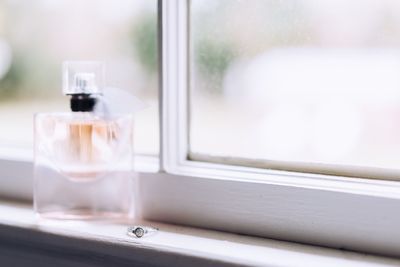 Close-up of ring with perfume on window sill