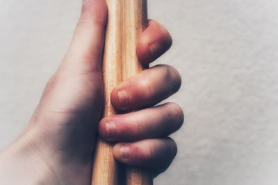 Close-up of hand holding hands over white background