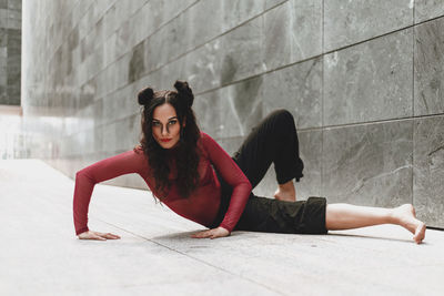 Full length of woman dancing on floor against wall