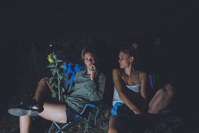 Beautiful women sitting outdoors at night