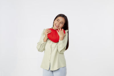 Portrait of smiling young woman against white background