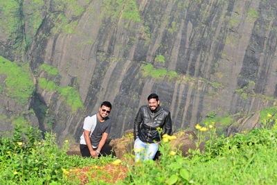 Young man and woman standing amidst plants in forest