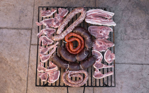 Grill full with different types of raw meat ready for getting cooked in the barbecue. close up.