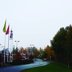 Road amidst trees against clear sky