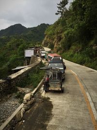 Car on road by mountain against sky