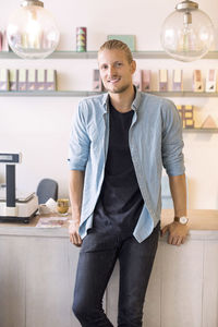 Portrait of smiling male owner standing candy store