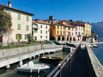 Canal amidst buildings in city against sky