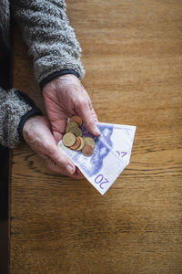 High angle view of hand holding coins