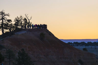 Group of people on rock against sky