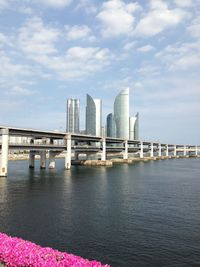 Bridge over sea against sky in city