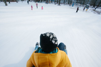 Rear view of people walking on snow covered land