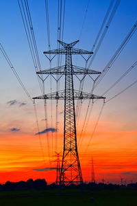 Electricity pylon against sky during sunset