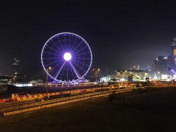 Illuminated ferris wheel at night