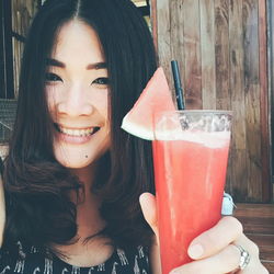 Portrait of smiling woman holding watermelon juice