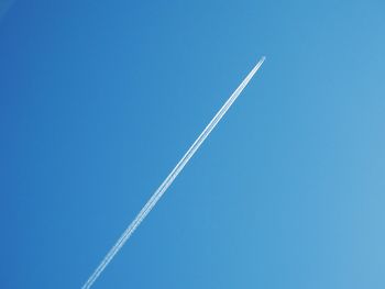 Low angle view of vapor trail in blue sky