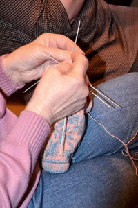 Midsection of woman knitting wool