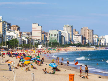 People at beach against sky