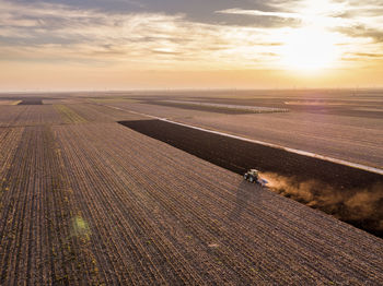 Serbia, vojvodina. tractor plowing field at sunset