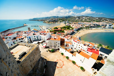 High angle view of townscape by sea against sky