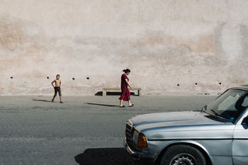 REAR VIEW OF PEOPLE STANDING ON ROAD AGAINST SKY