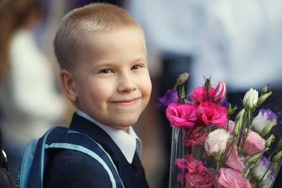 Portrait of smiling boy with red flower