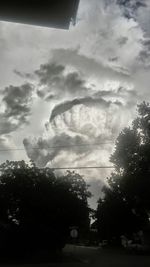 View of trees against cloudy sky