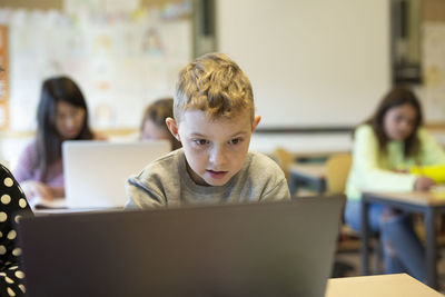 Portrait of boy sitting on laptop