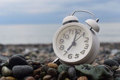 Close-up of alarm clock at pebble beach